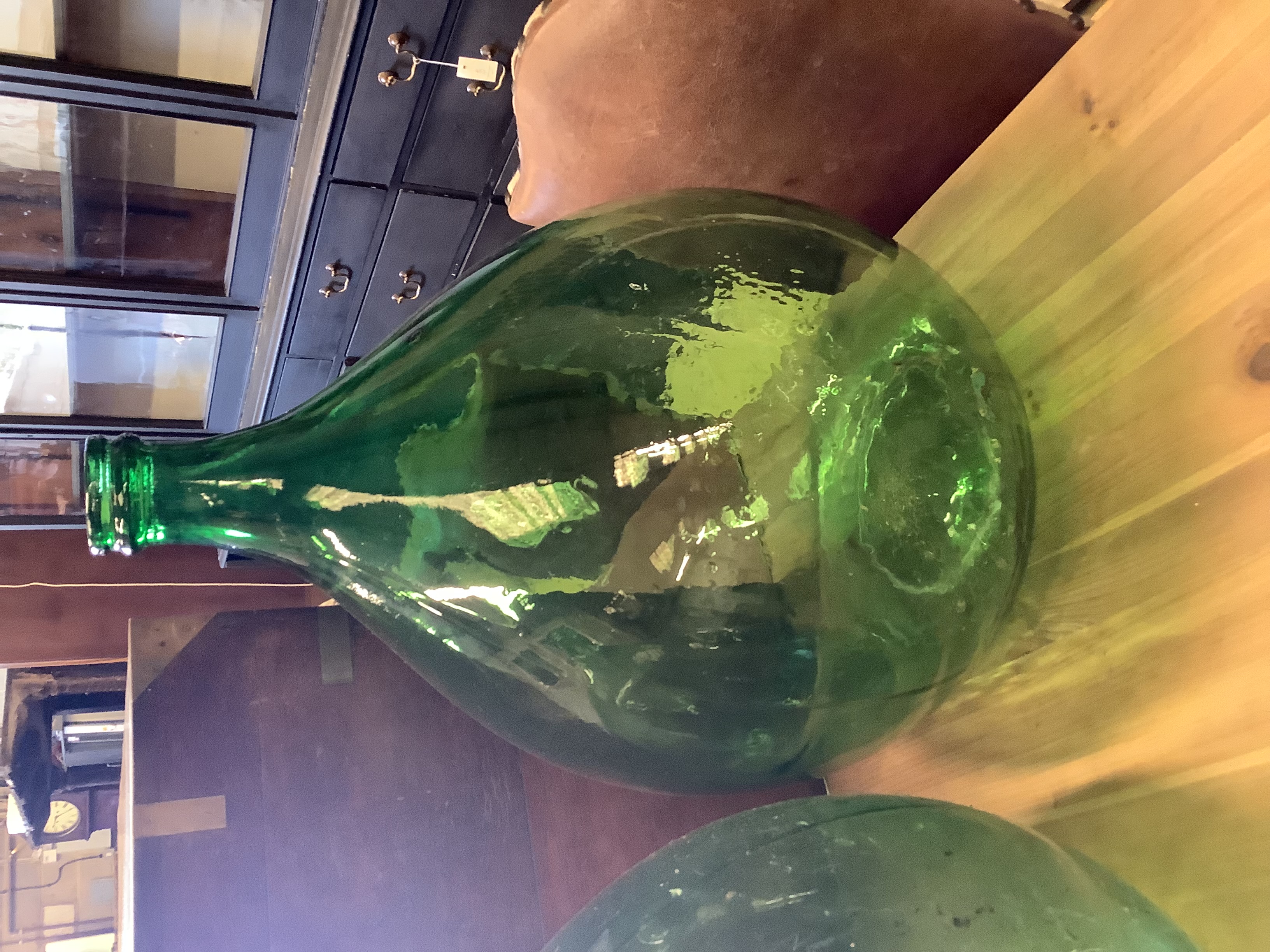 A pair of green glass carboys, height 64cm